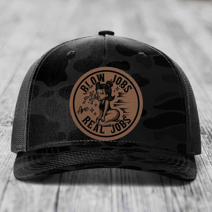 Black camouflage trucker hat with brown circular leather patch featuring cartoon woman and text &
