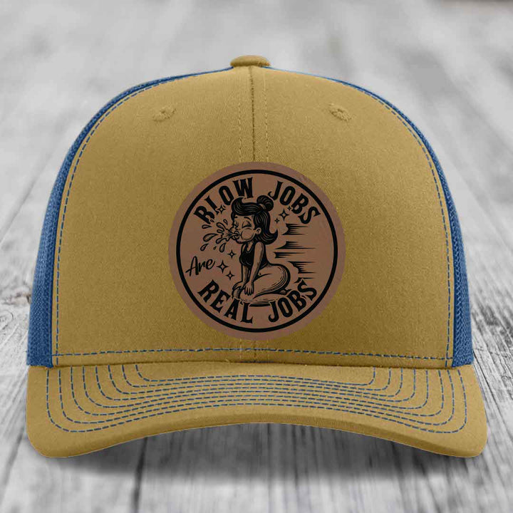 Tan and blue trucker hat with a circular brown leatherette patch that reads &