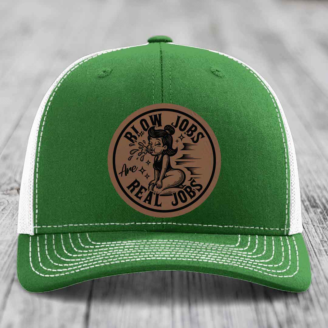 Green trucker hat with white mesh back and stitching, featuring a brown circular leatherette patch that reads &
