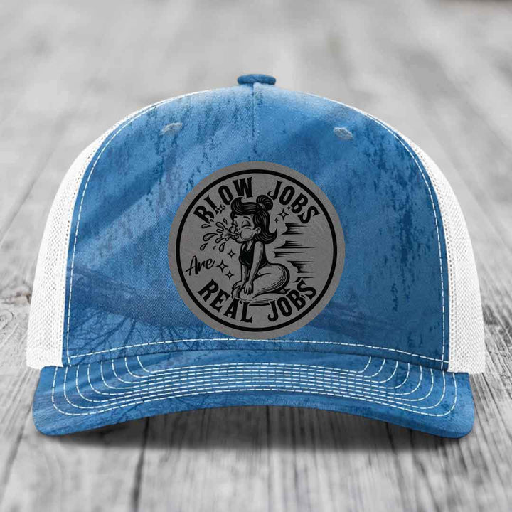 Blue and white trucker hat with a circular black and grey patch that reads &