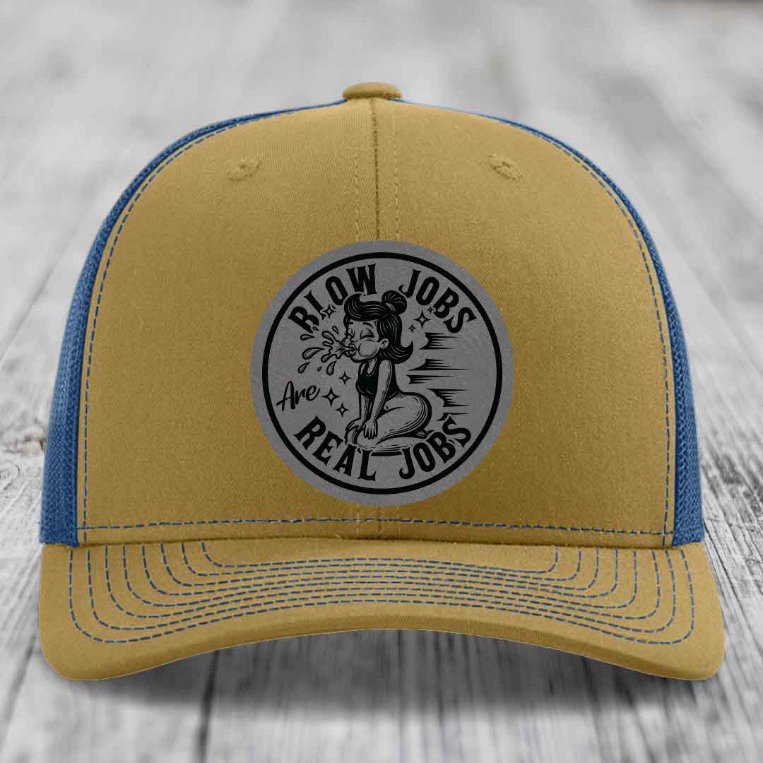 Tan and blue trucker hat with a circular gray patch featuring a cartoon woman blowing bubbles and the text &
