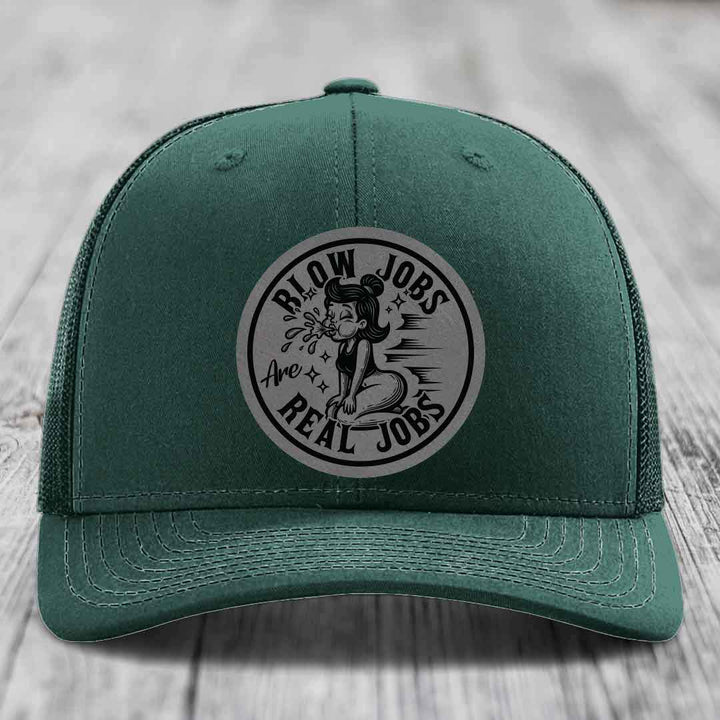 Green trucker hat with circular grey patch showing cartoon woman and text &