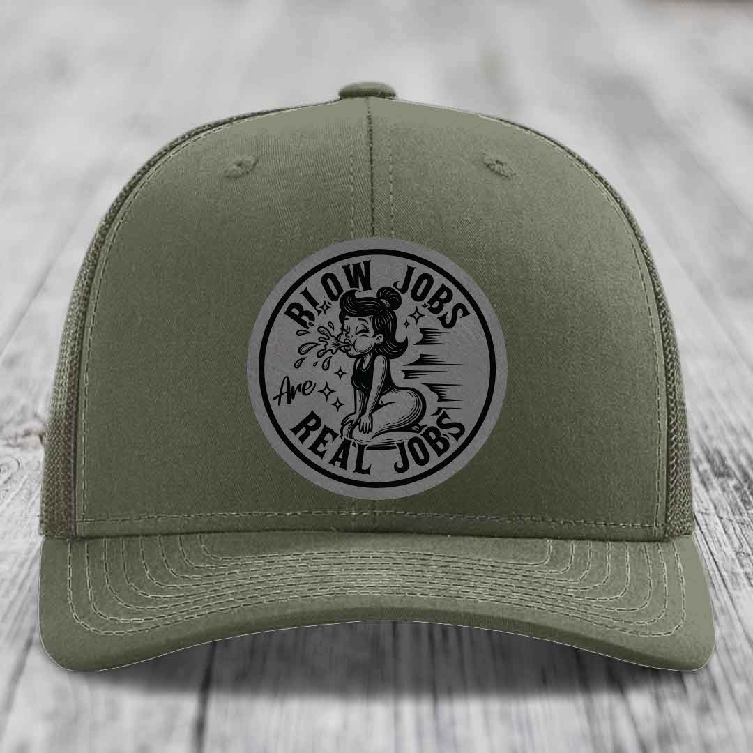 Olive green trucker hat with a circular grey patch featuring a cartoon woman and the text &