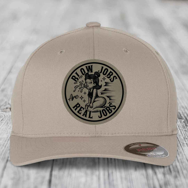 Beige baseball cap with black circular patch reading &