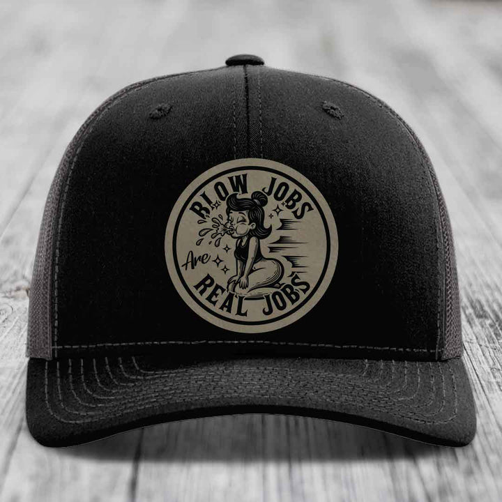 Black trucker hat with circular beige patch reading &
