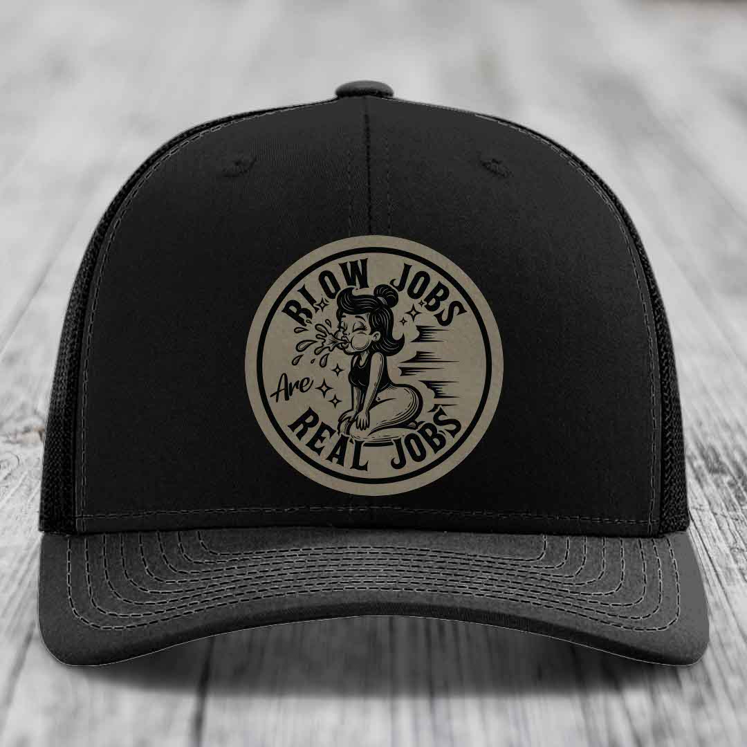 Black trucker hat with circular beige patch featuring cartoon woman and text &