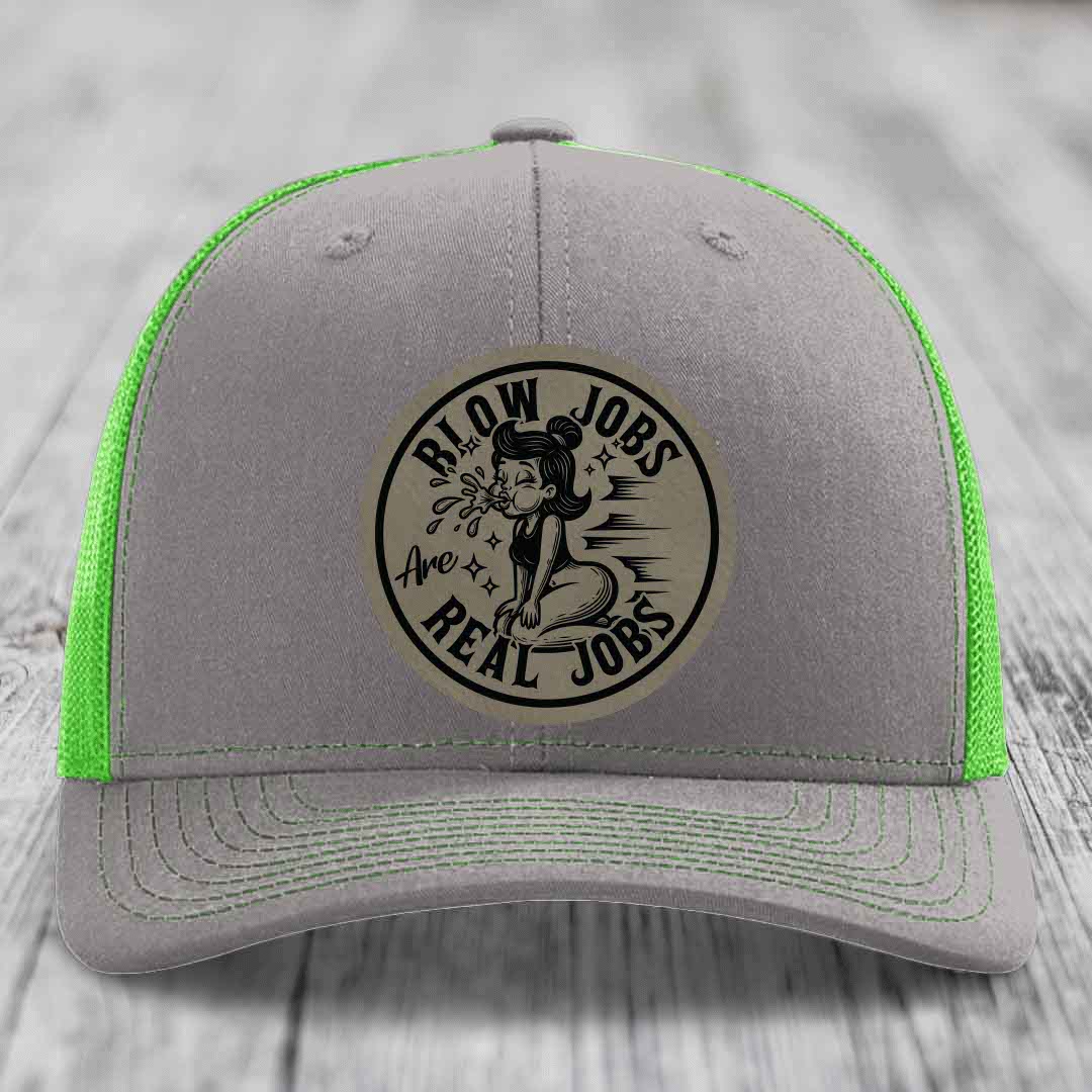 Grey trucker hat with neon green mesh and stitching, featuring a circular leatherette patch that reads &