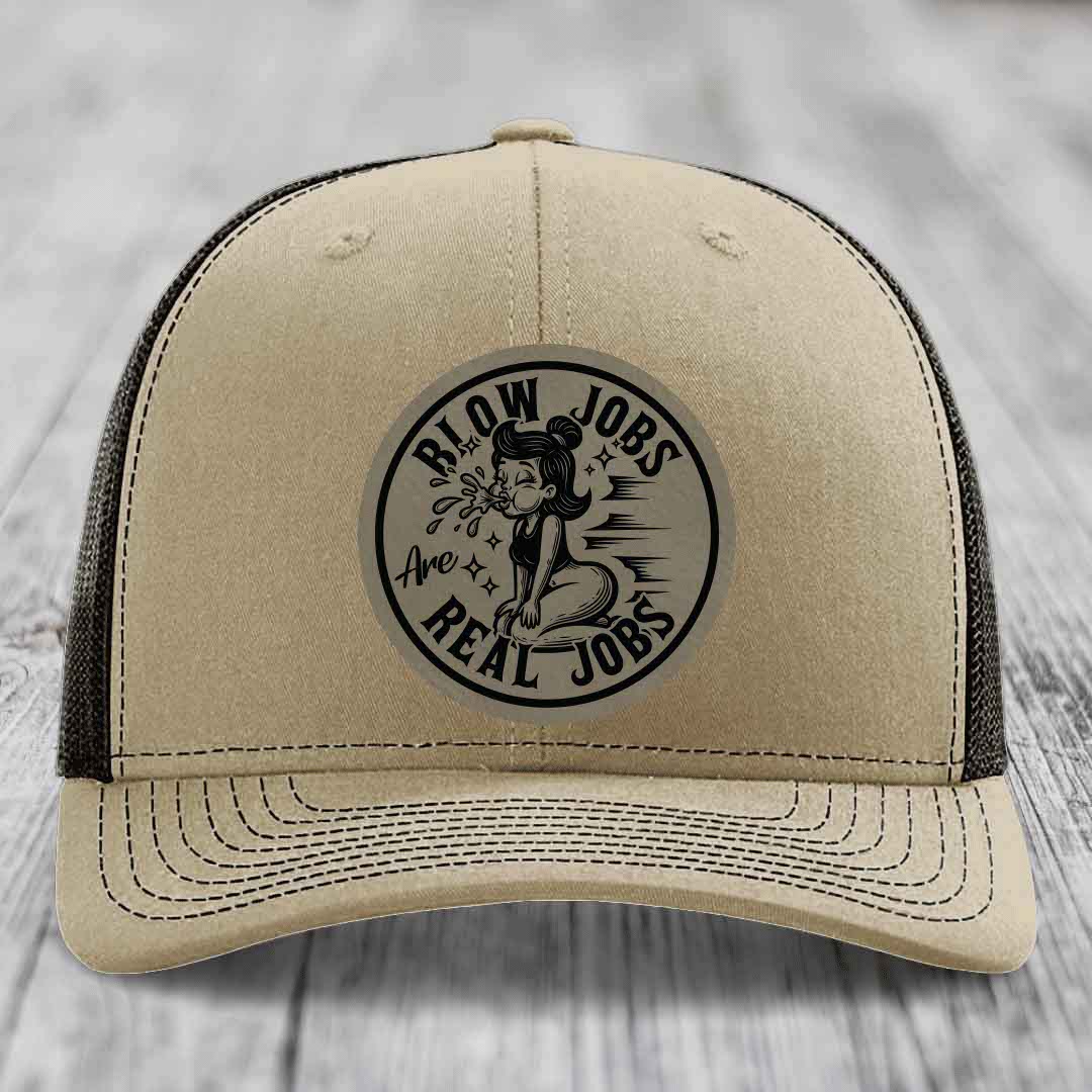 Tan trucker hat with black mesh back and a circular black-and-white graphic patch reading &