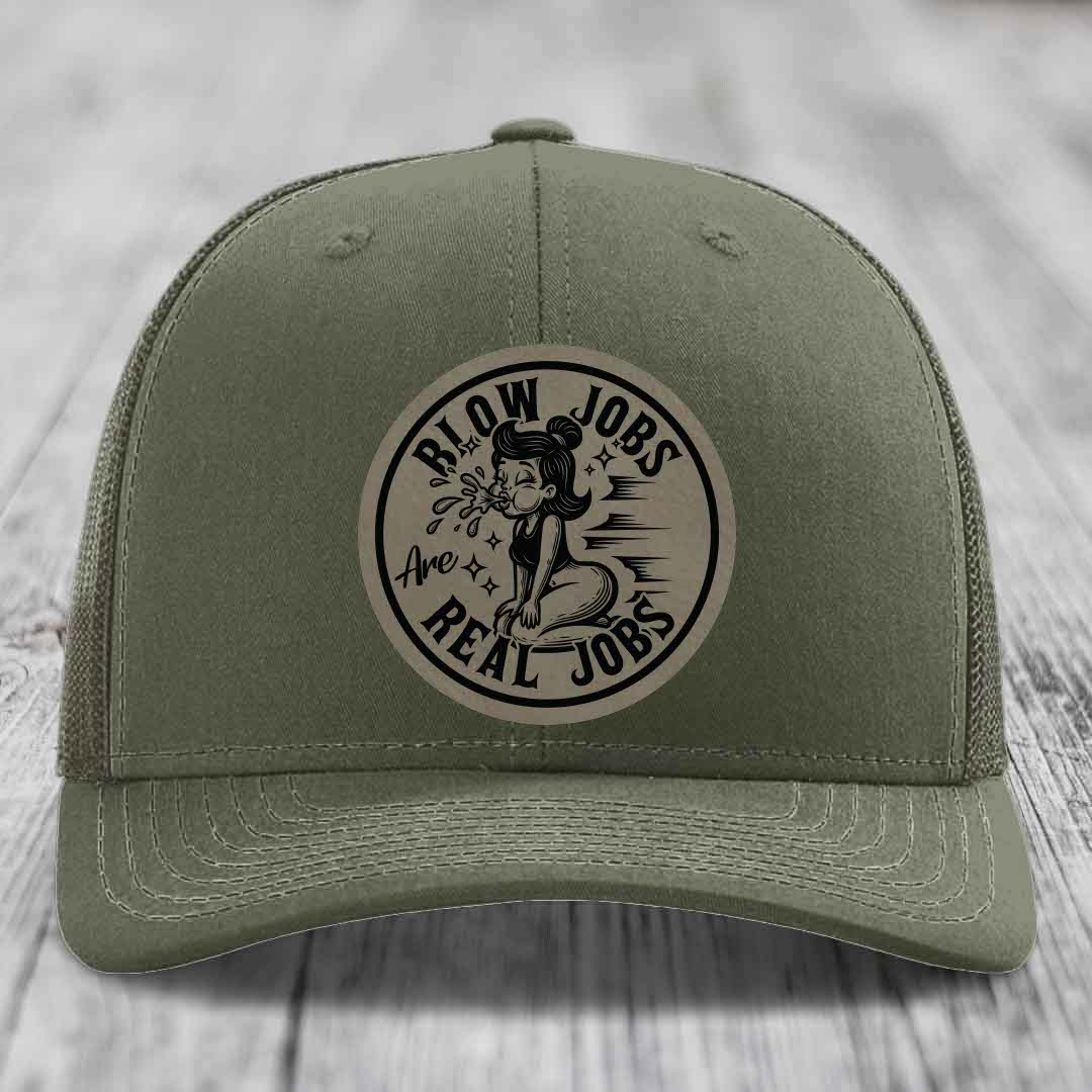 Olive green trucker hat with circular beige patch featuring black text and illustration.