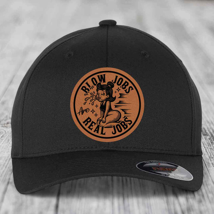 Black baseball cap with circular brown leatherette patch featuring cartoon woman and text &