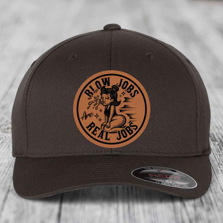 Dark brown baseball cap with circular tan leatherette patch reading &