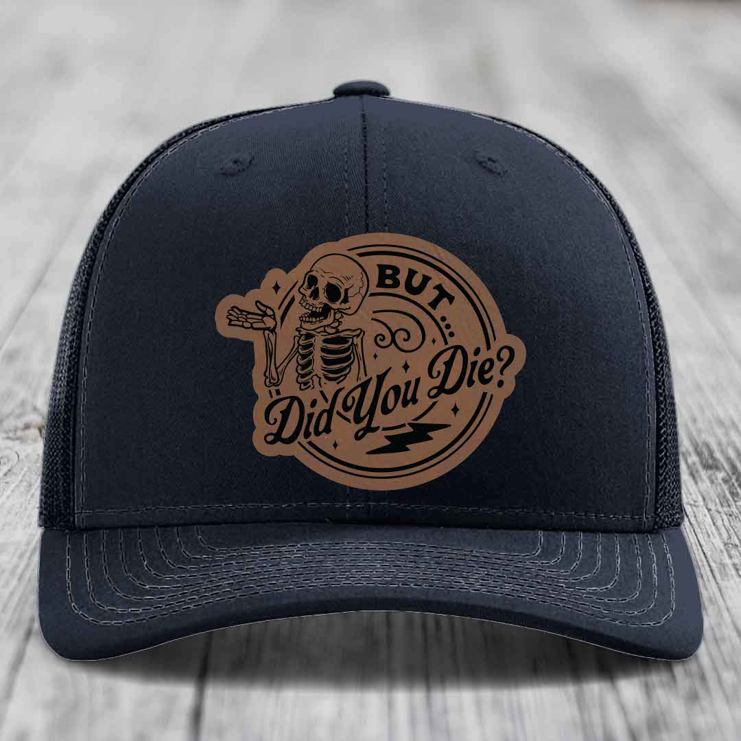 Black trucker hat with brown leather patch featuring skeleton and text &