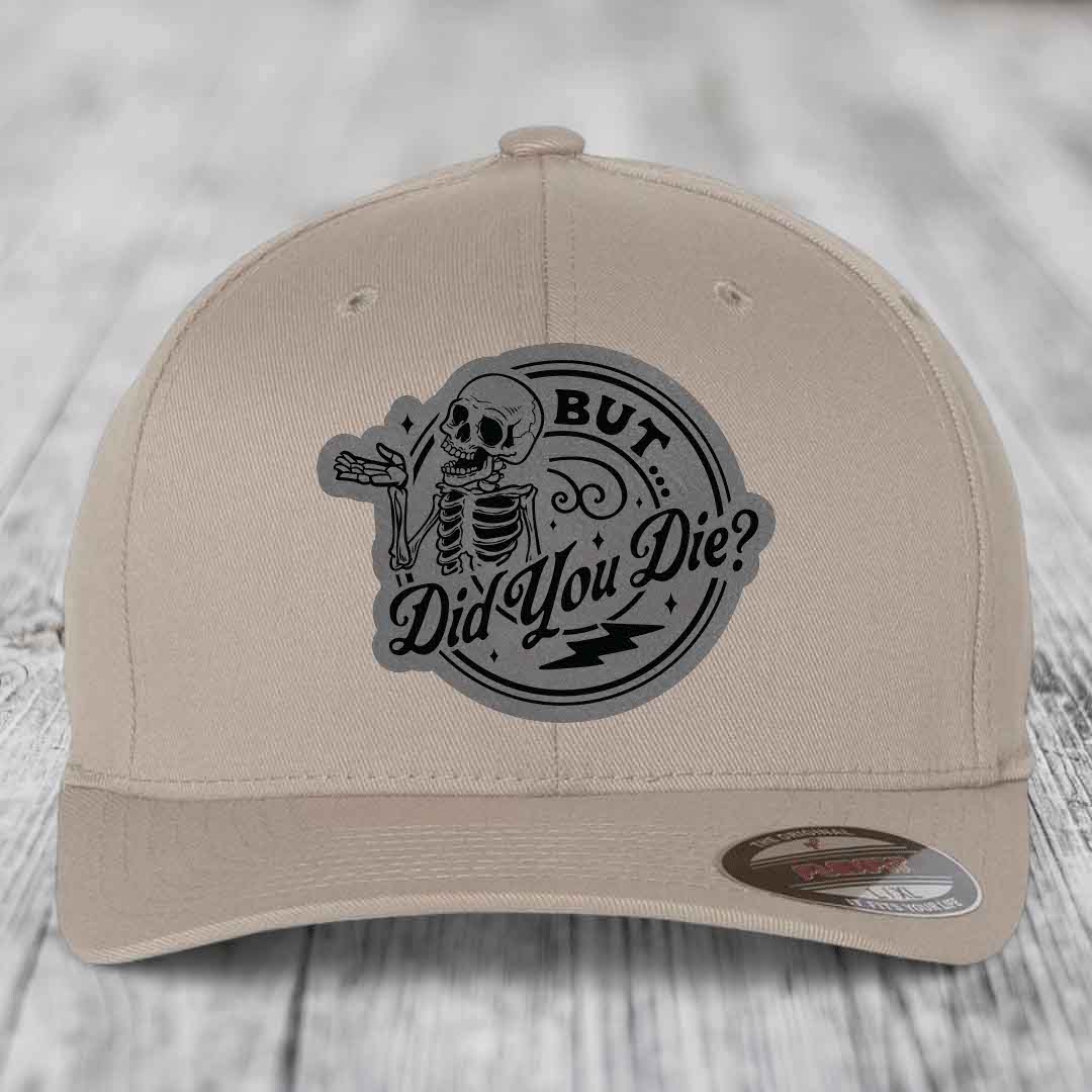 Beige baseball cap with a black skeleton patch reading &