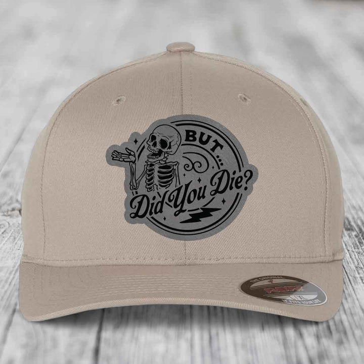 Beige baseball cap with a black skeleton patch reading &