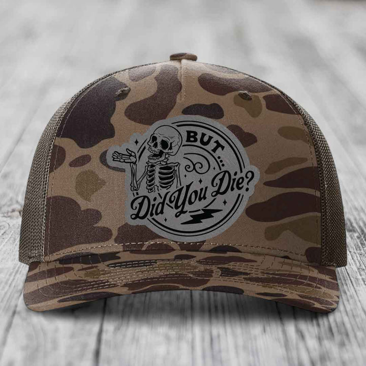 Camouflage trucker hat with a skeleton patch that reads &