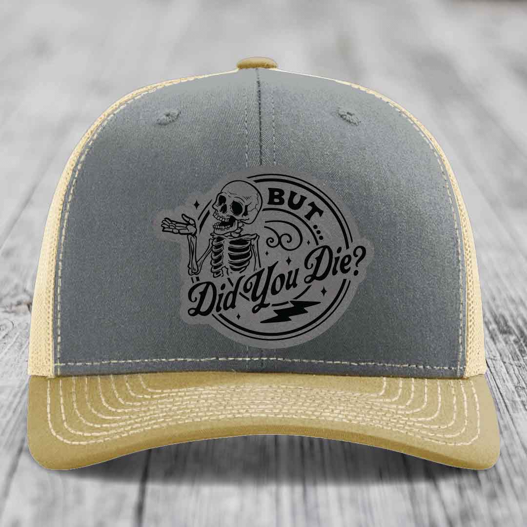 Grey and beige trucker hat with a skeleton graphic and text reading &