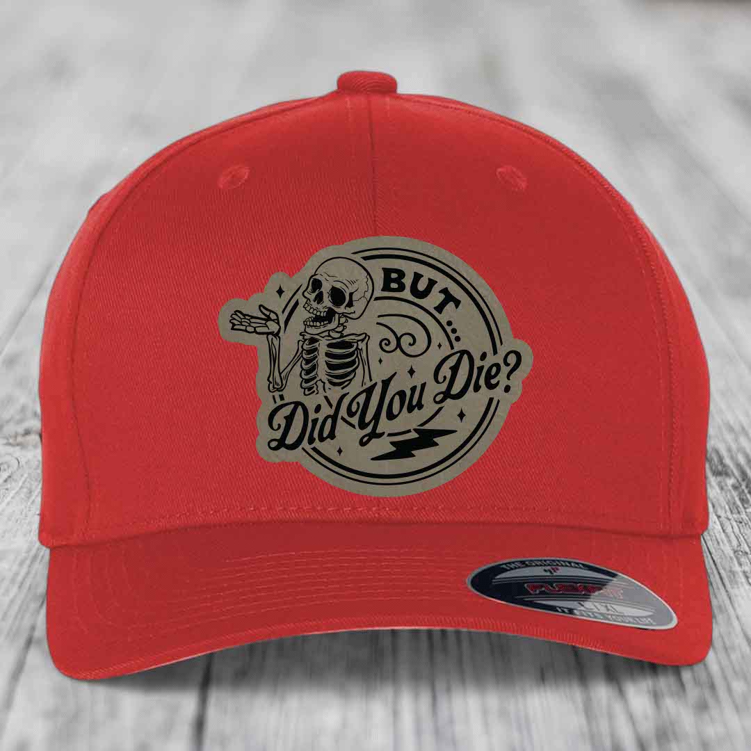 Red baseball cap with a circular beige patch featuring a skeleton and the text &