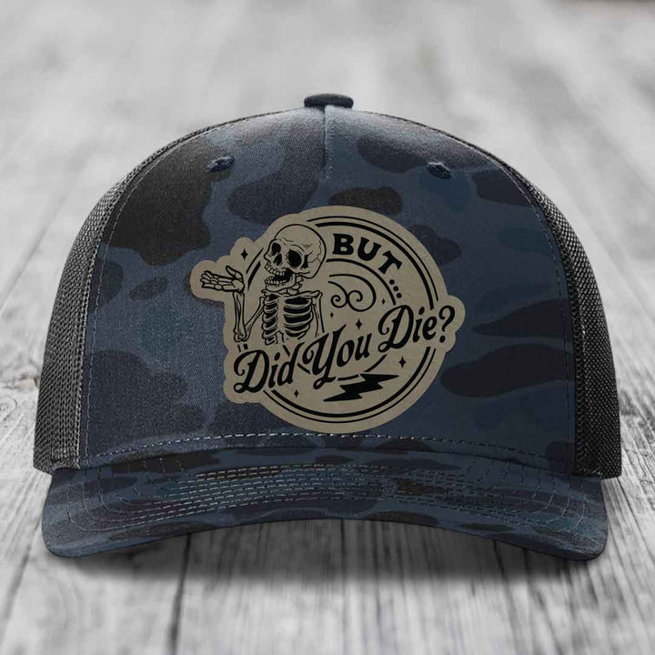 Camouflage trucker hat with a skeleton patch that reads &