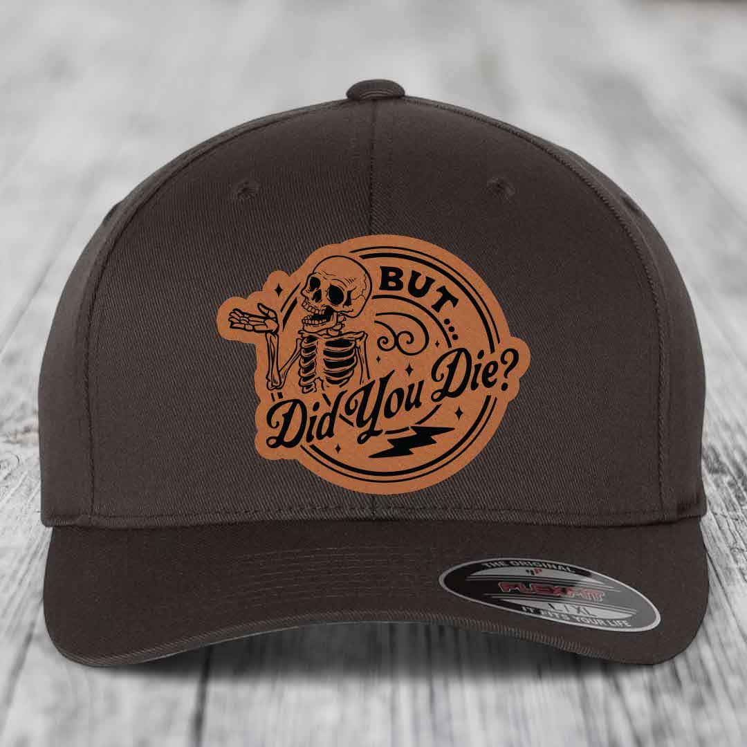 Dark brown Flexfit hat with a tan leatherette patch featuring a skeleton and the text &