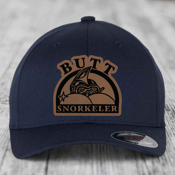 Dark blue baseball cap with brown leatherette patch reading &
