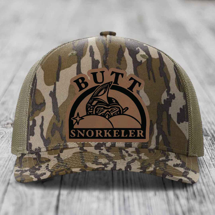 Camouflage trucker hat with brown leather patch reading &
