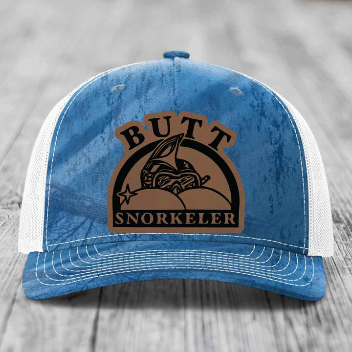 Blue and white trucker hat with a brown leatherette patch that says &