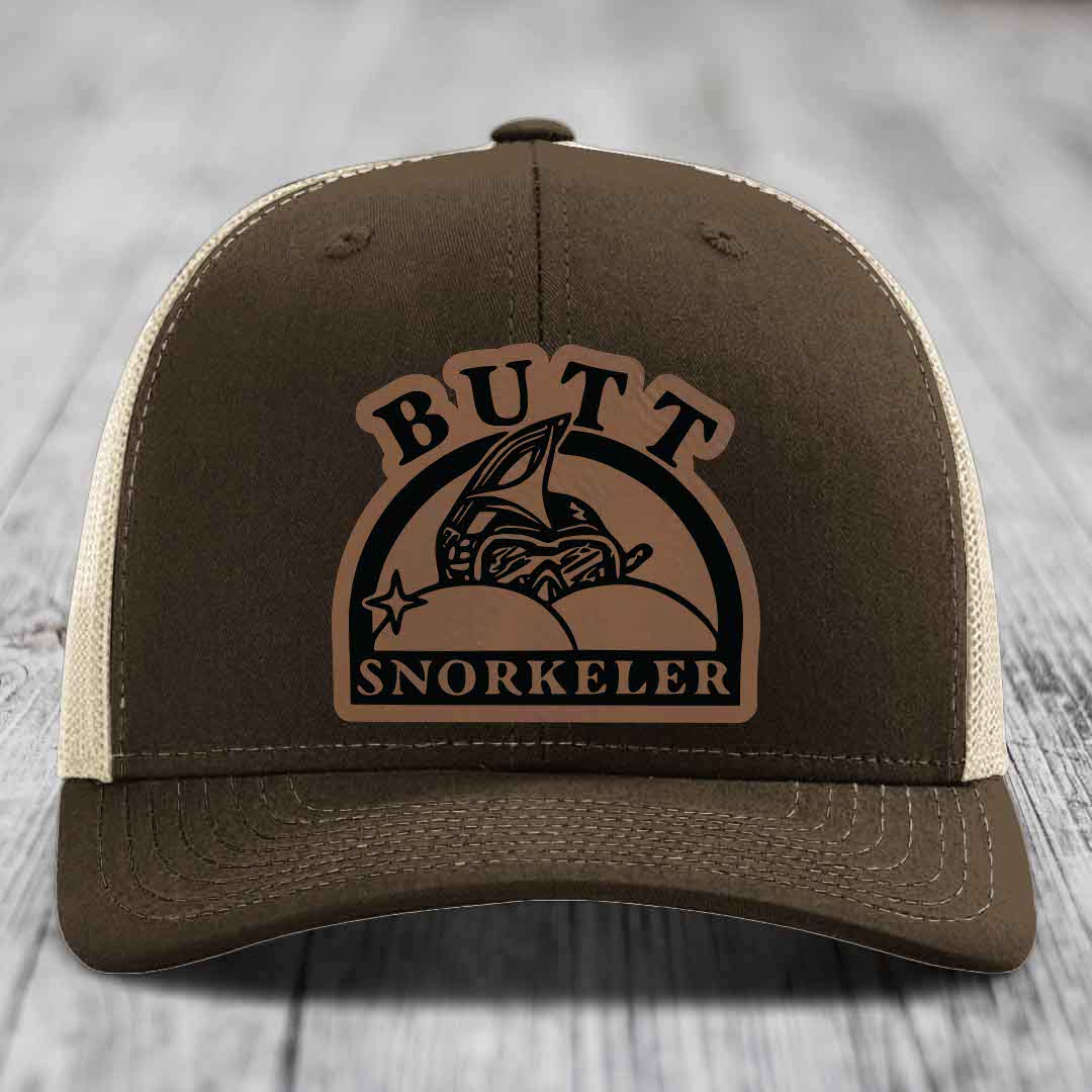 Brown trucker hat with beige mesh back and a brown leather patch that reads &
