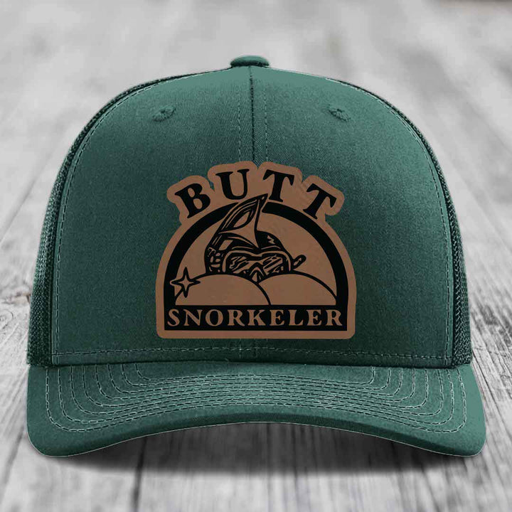 Green trucker hat with brown leatherette patch reading &