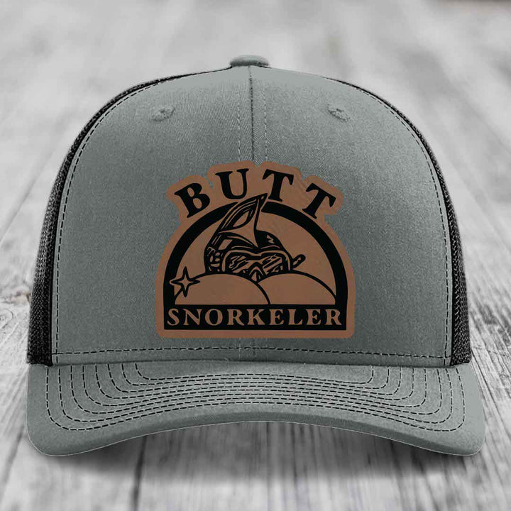 Grey trucker hat with brown leather patch reading &