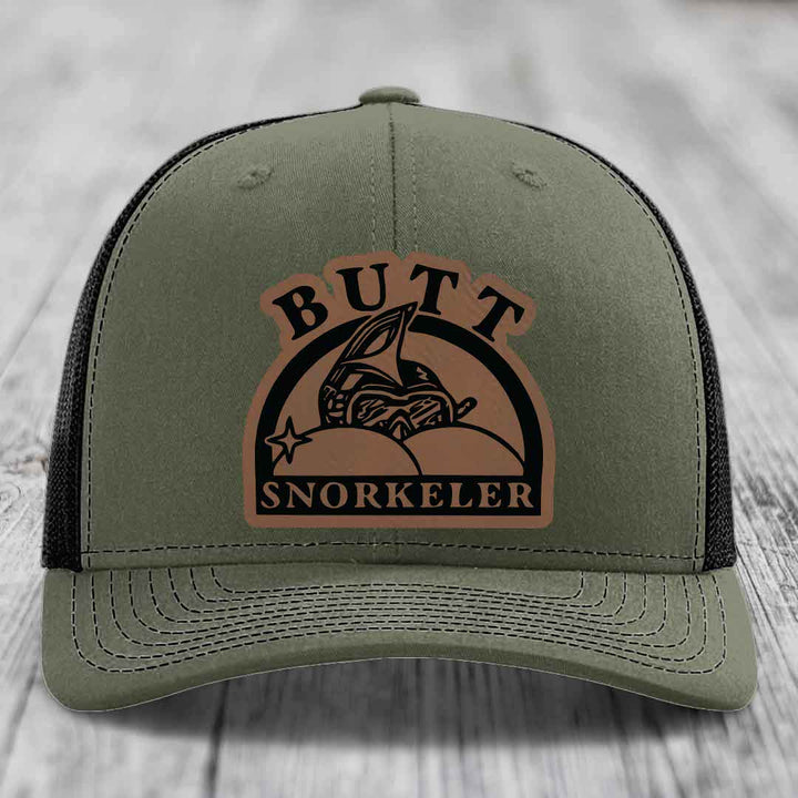 Olive green trucker hat with brown leather patch reading &