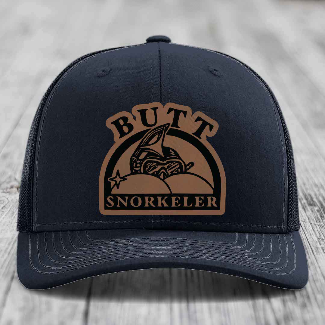 Black trucker hat with brown leather patch reading &