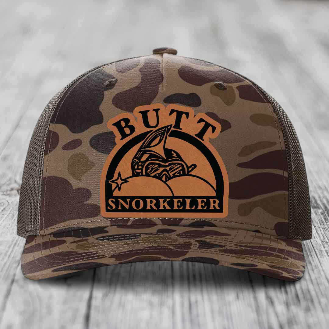 Camouflage trucker hat with brown leather patch reading &
