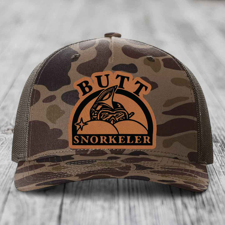 Camouflage trucker hat with brown leather patch reading &
