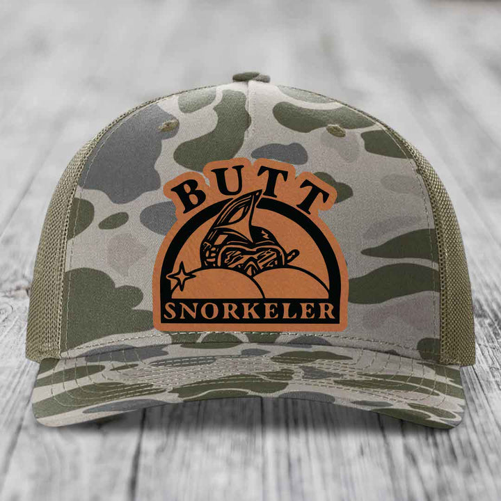 Camouflage trucker hat with brown leather patch reading &
