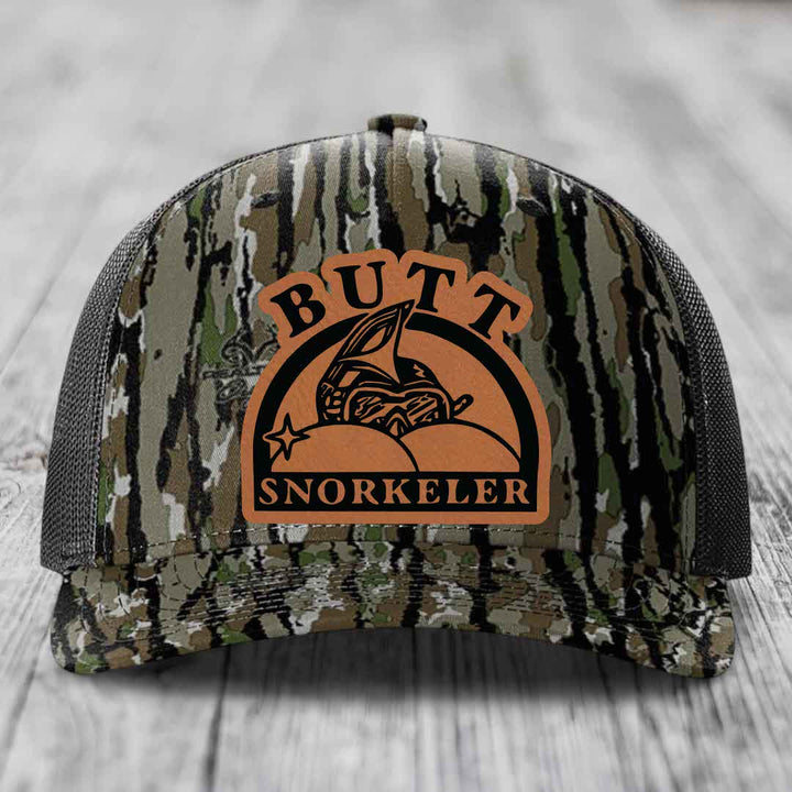 Camouflage trucker hat with brown leather patch reading &