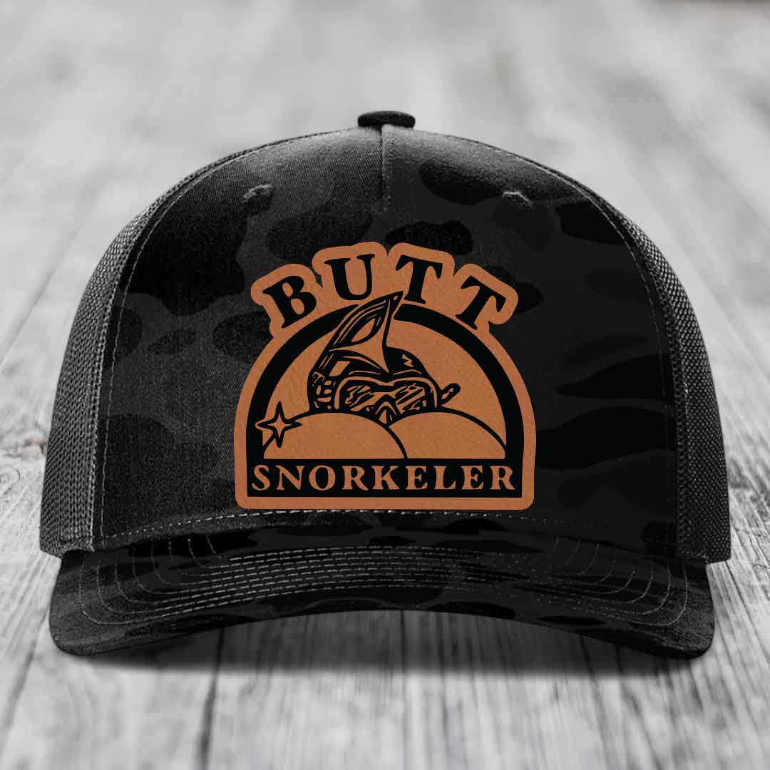 Black trucker hat with brown leatherette patch reading &