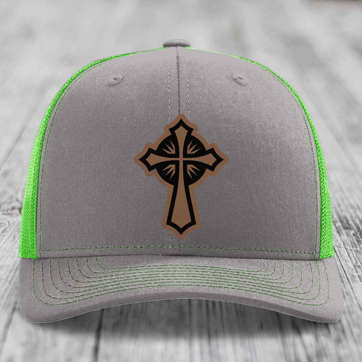 Grey trucker hat with neon green mesh and stitching, featuring a brown cross leather patch on front.