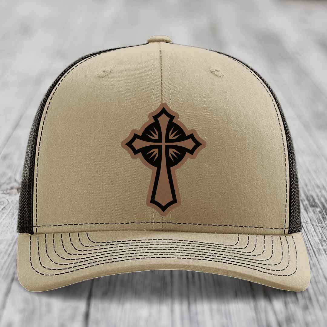 Beige trucker hat with a brown and black cross leather patch on the front.