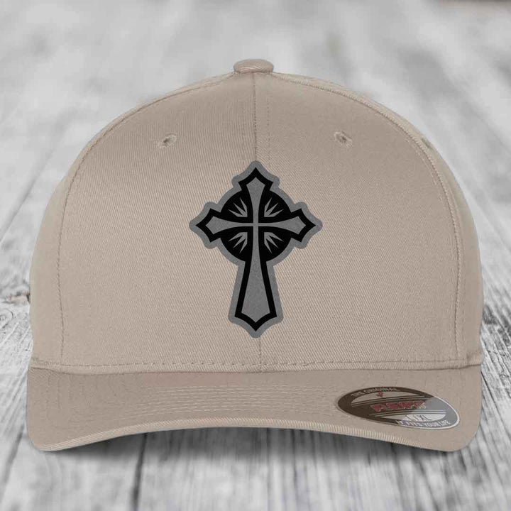 Beige baseball cap with black and grey cross patch on front, branded Flexfit label visible.