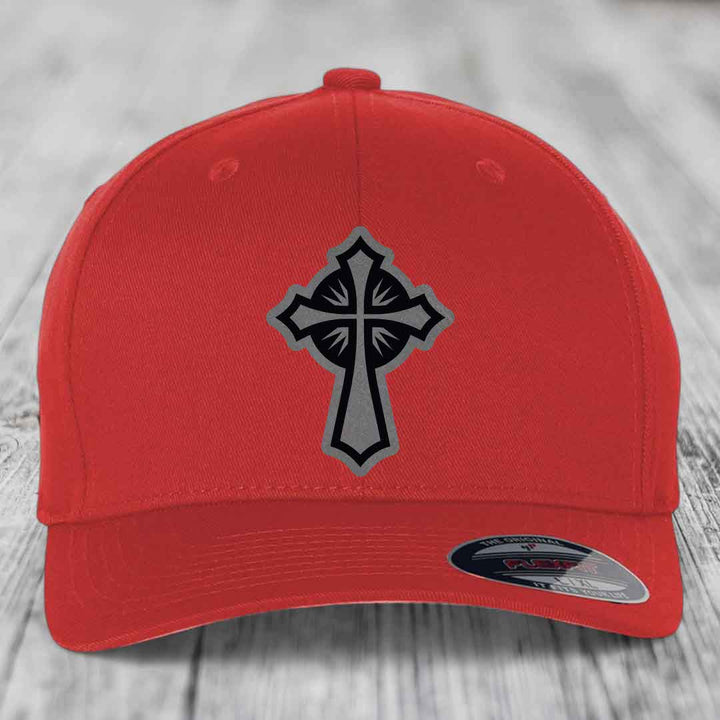 Red baseball cap with black and grey cross patch on front, Flexfit label visible.