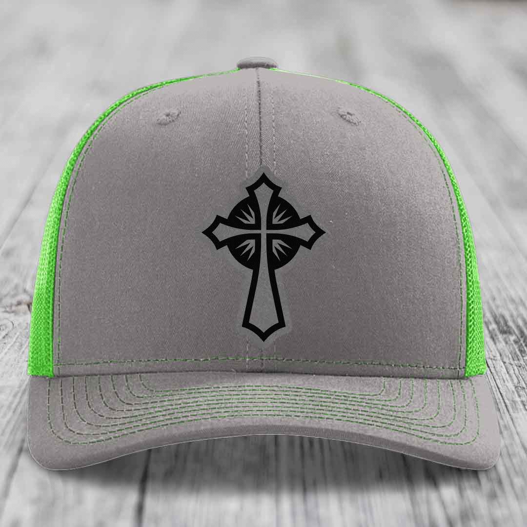 Grey trucker hat with black cross patch and neon green mesh sides.