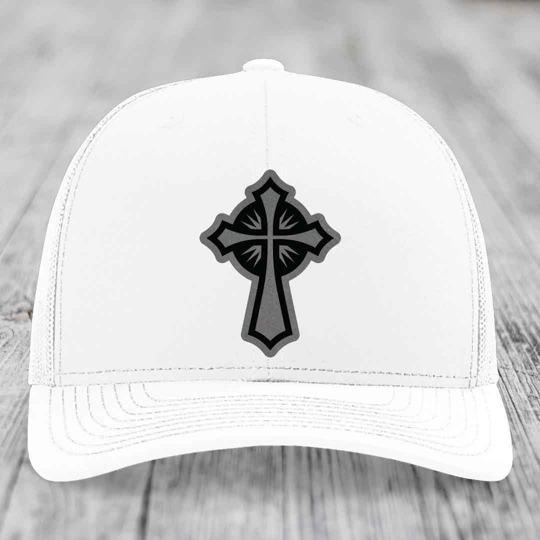 White trucker hat with black and grey cross leather patch on front.
