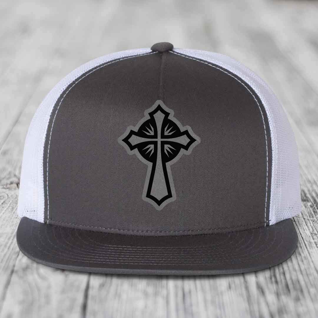 Grey and white trucker hat with black cross patch on front.