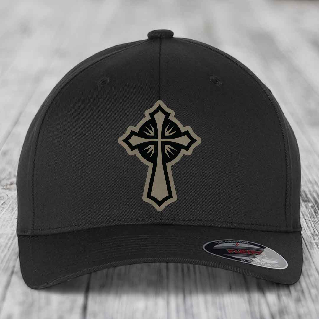 Black baseball cap with a beige and black cross patch on the front.