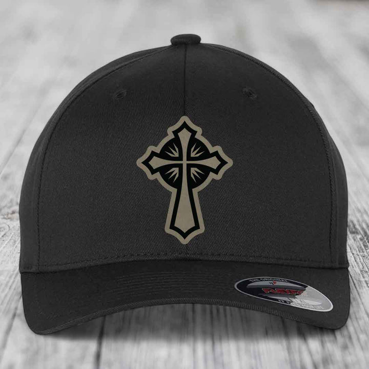 Black baseball cap with a beige and black cross patch on the front.