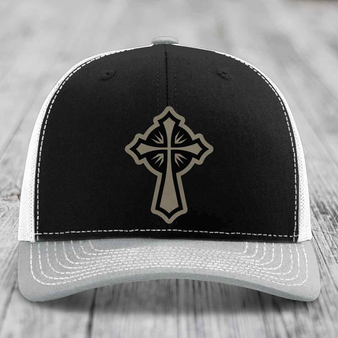 Black trucker hat with grey cross patch and white stitching on front panel.