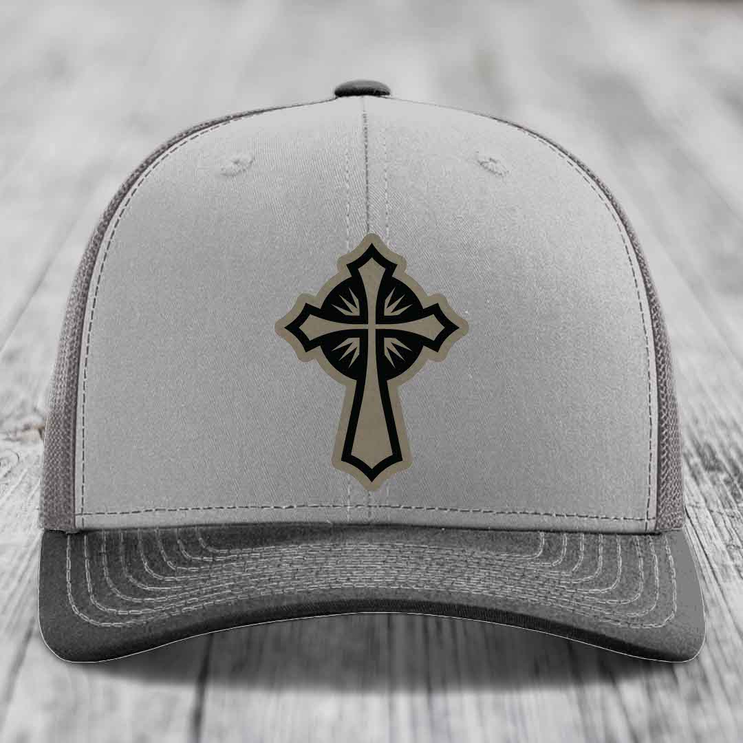 Grey trucker hat with black and tan cross leather patch on front.