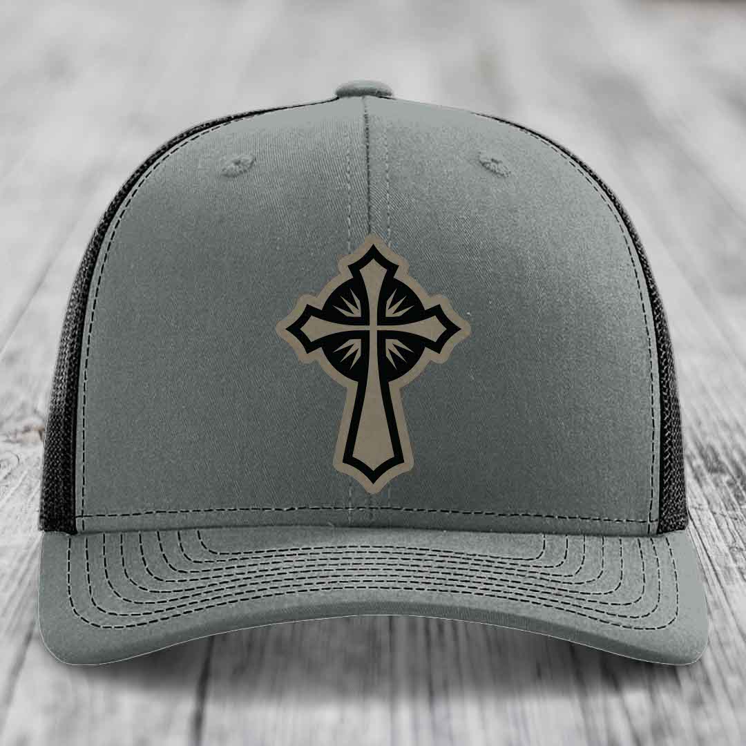Grey trucker hat with black and tan cross leather patch on front.