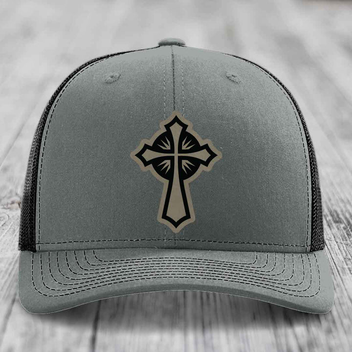 Grey trucker hat with black and tan cross leather patch on front.