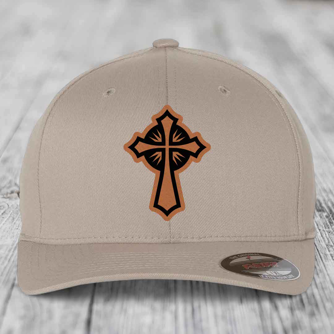 Beige baseball cap with a brown and black cross leather patch on front.